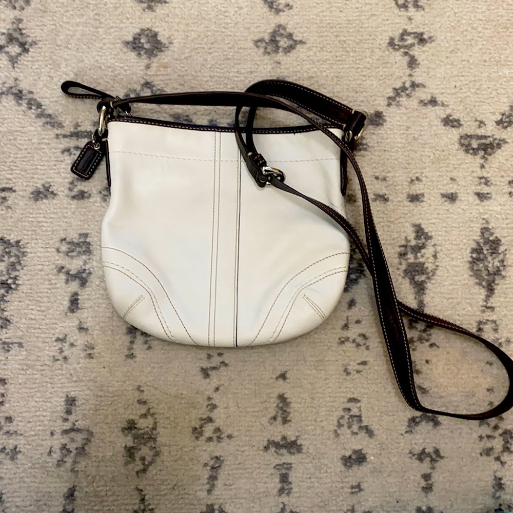White Coach bag with brown strap.